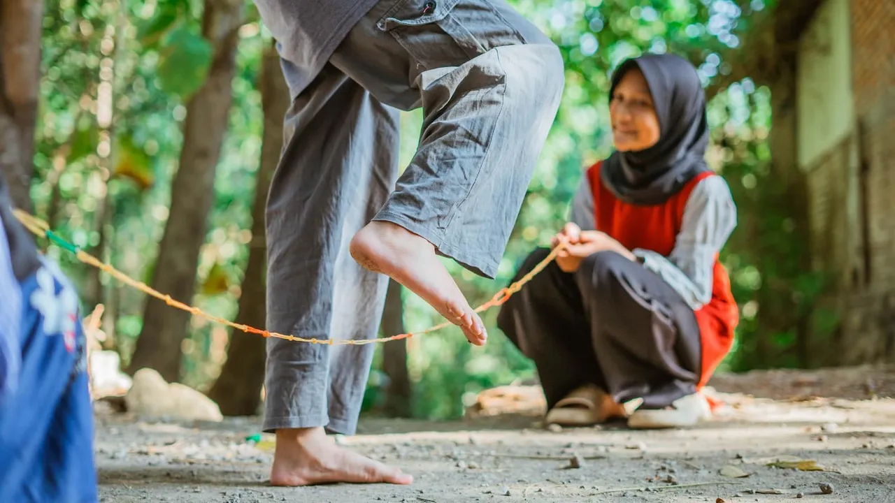 Lompat tali karet adalah salah satu permainan tradisional yang sering dimainkan anak sekolah